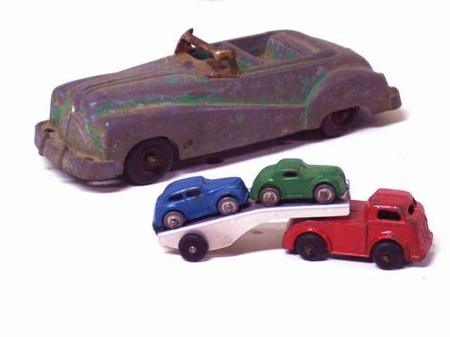 There are both stamped and cast metal cars pictured here including
				a stamped car carrier and a cast large green roadster.