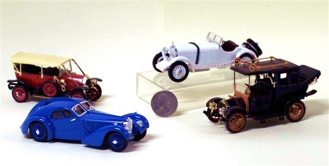 Several loose Rio toy autos are shown here and described below: A red 1912 Fiat Torpedo Model 0, a white 1931 Mercedes SSKL, a blue 1938 Bugatti Tipo 57 SC coupe, and a green Bianci Landaulet.