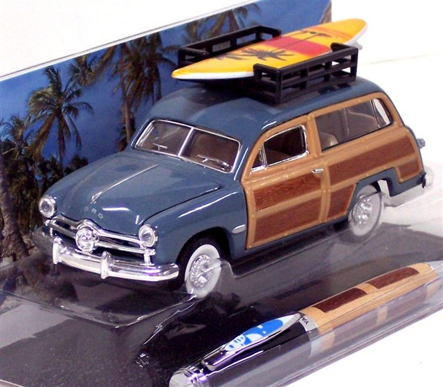 The '49 Ford woodie wagon in the photo was sold with a matching ink pen. The box includes a molded plastic base and background which pictures a sandy beach and palm trees against a clear blue sky.