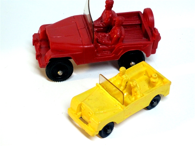  At top is a Tomte Laerdahl red Willys Jeep with two soldiers, at below it a yellow Land Rover cabriolet with driver, passenger, and a dog, both vehicles fitted with black wheels, each 4 inches long.