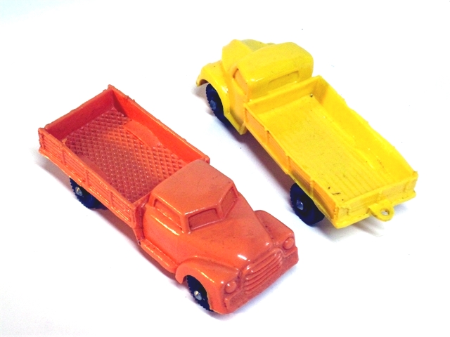 Tomte Laerdahl's trucks are all wonderfully produced. Here we have a coral Chevrolet stakeside and a yellow Dodge stakeside, all with black wheels, all approximately 4 inches long.
