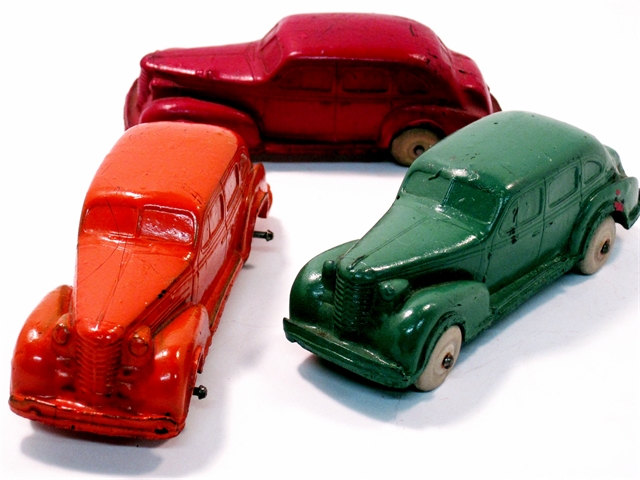 A group of three Auburn 1937 Oldsmobile 4-door sedans, one red, one green, and one orange.