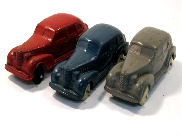 A group of three Auburn 1937 Oldsmobile 4-door sedans, one red, one blue, and one gray.
