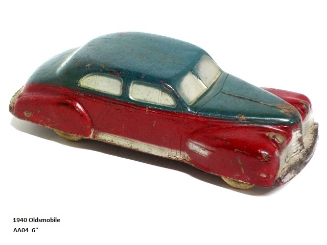 A Christmas green over red, 1940 Oldsmobile with closed fenders. It has silver windows, grill and headlights. The body is long and low, and is 6 inches long. The driver can be seen cast with the car in the driver-side window.