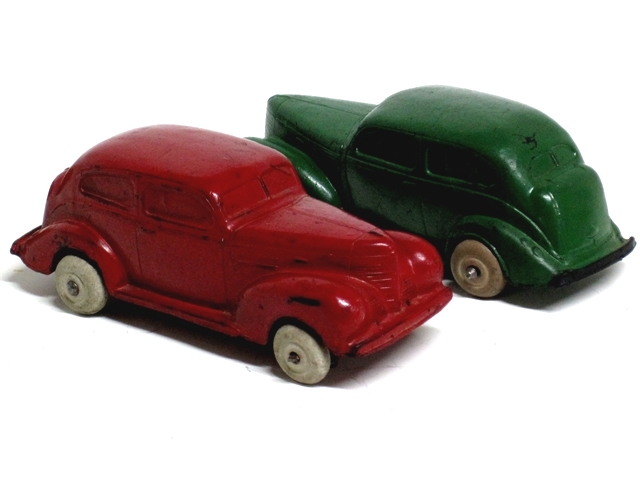 Front quarter view of a red and a green '39 Plymouth. They have the lovely, sweeping styling of the 1940 Ford coupes except of course that they are Plymouths. Yes, lovely.