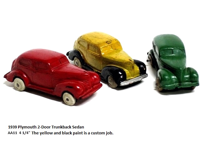This is a trio of lovely 1939 Plymouth two doors, seen from the upper front. One is red, one is green, and in the middle is one that is yellow with black fenders and running boards. The bumpers are silver and the wheels are white. 