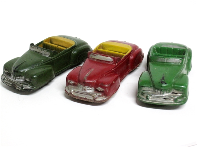 A trio of '46 Lincolns, one green with round headlights, one red with round headlights, and one green with square headlights, seen from the left front quarter. The Lincolns with round headlights have yellow interiors.