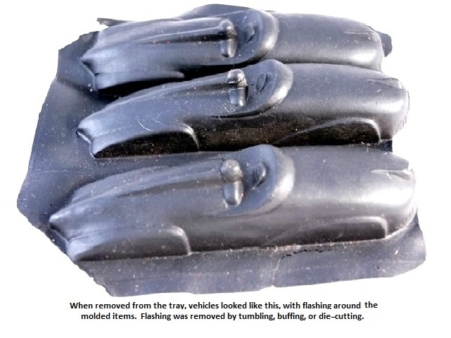 A 3-car mold of the ar08 open Auburn race cars before trimming and paint. The molded race cars are black rubber. The flashing around the cars is removed by tumbling, buffing, or die cutting.