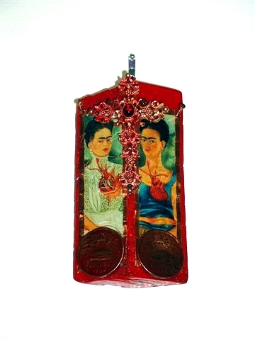 A red laquered wooden block with part of The Two Fridas attacked. atop it is a jewelled pink metallic cross and at the bottom, two Mexian peso coins.
