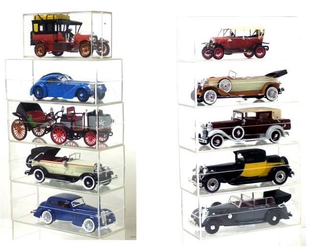 There are two stacks of Rio vehicles in this photo. The left stack, top to bottom: First is a red 1908 Mercedes Touring car with bright yellow luggage stacked on the roof, which is solid over the passenger compartment and folding material over the driver. The car is right hand drive and has wooden wheels.
				Next is a blue 1938 Bugatti Tipo 57 SC coupe Atlantic. This beautiful two-passenger machine has a sleek fastback style body seemingly made in two halves and bolted, one to the other, through a ridge along the middle of the roof. The windscreen is swept back, and there are suicide doors. The classic Bugatti radiator shell is present. The wheels are blue wires. Jay Leno has a faux example of this car and a great video.
				Below it, an 1984 DeDion Bouton with a front driver's section and an attached passenger section. Steering is by tiller. The vehicle is grey with large red wheels.
				Below this, is a right hand drive Isotta Fraschini T8A, circa 1925. It is an open touring car with a half top over the back seat. The car body is cream white with a red stripe, and it has black fenders and running boards. The wheels are black with wide white sidewall tires.
				Last in the stack is a blue 1937 Mercedes Benz cabriolet with a fixed top, large streamlined fenders, no running boards, and a trunk back style trunk. There are chrome wire wheels and large white sidewall tires. The car is right-hand drive.
				The right hand stack, again top to bottom: A bright red, right hand drive 1912 Fiat Torpedo Model 0 with four doors and black fenders, running boards, and splash aprons, and red wooden wheels. There is a tool box on the passenger's side running board. On the driver's there is a container for gas to operate the lights, and a spare wheel and tire (which blocks the driver's door). The bulb-operated horn and brake control are outside the car by the driver. The full length top is up, revealing an oval rear window. Upholstery is black. The front windscreen is two-part. Leather straps attach to the front corners of the top and to the front fenders, securing the top. There are bullet shaped headlights and cowl lights but no tail light. The horn The crank is present. Suspension was by semi-elliptical leaf springs front and rear. The radiator shell and all other metal trim is brass plated.
				Next is a 1926 Fiat Tipo 519 S open touring in caramel over cream with caramel fenders and running boards, chromed wheels, including both sidemount tires, a luggage rack at the rear and two chrome step plates on each side replacing the running boards. The fenders are all quite long and low. The upholstery in a pinkish cream color and not very well done. The dash is black with black gauges, and the floor mounted gearshift and emergency brake are chrome. The windscreen is angled back from a center post, giving a dramatic effect, as does the back of the body, which comes together in the middle to create a seagull effect. The hood is removable, revealing a silver motor with typically fine Rio detail.
				Below the Fiat is a maroon, right hand drive 1929 Isotta Fraschini 8A with light grey fenders and running boards and splash aprons. A tool box sits on both of the running boards. The driver's compartment is separate from the passengers, having a window in between. The tuck and roll upholstery is bright tan, almost orange. Doors all open conventionally but there may not be windows for the drivers area. Perhaps side curtains were used. The hood lifts off, revealing a well-detailed silver motor. There are two sidemount spare tires and knockoff hubs. The wheels are maroon artillery style. A large truck sits on a rack at the back. The light tan top is up, highlighted by chromed landau arms. The windows are roll-up, and the rear window is a somewhat small rectangle.
				Rio is fond of Bugatti automobiles and has released many variations. Here we have a 1928 Bugatti Royale 41 Weymann Coupe Fiarce, a very long and low sporty automobile painted black and yellow. The back of the car is bright yellow and is black for the front half. The yellow scoops is classic Bugatti style. There are chrome wheels and a single, rear-mounted spare. What looks like a black trunk sits atop the part of the body where a trunk is usually found (storage is available from inside the car behind the two bucket seats). The body seems quite truncated, with an odd, high roof that to me is quite unattractive. Upholstery is white and the dash is orange.
				Last comes a massive grey 1937 Mercedes Benz cabriolet with dark grey fenders and red tuck and roll upholstery. There are two conventional front doors and two suicide-style back doors. For more seating, two fold down jump seats are included. The body had a trunk-back bustle for storage of luggage. There is a windscreen divider between the driver seat and the rear seat. There are two fender mounted spare tires protected by metal tire covers. The black disc wheels were mounted with blackwall tires. It is, all in all, an amazing model.
