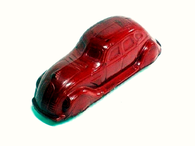 A red Sun Airflow. Long and narrow, with four suicide doors and the classic Airflow radiator grille, the toy is a perfect fit for a child's hand.