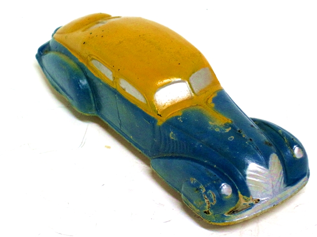A bright blue Teardrop Sedan with yellow roof, silver windows, grill, and radiator shell as viewed from the left front.