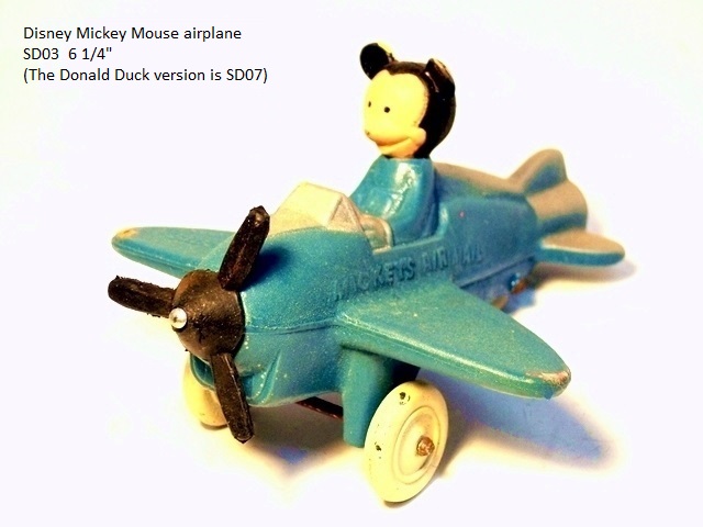 A light blue single engine airplane piloted by Mickey Mouse, viewed from the front quarter.
