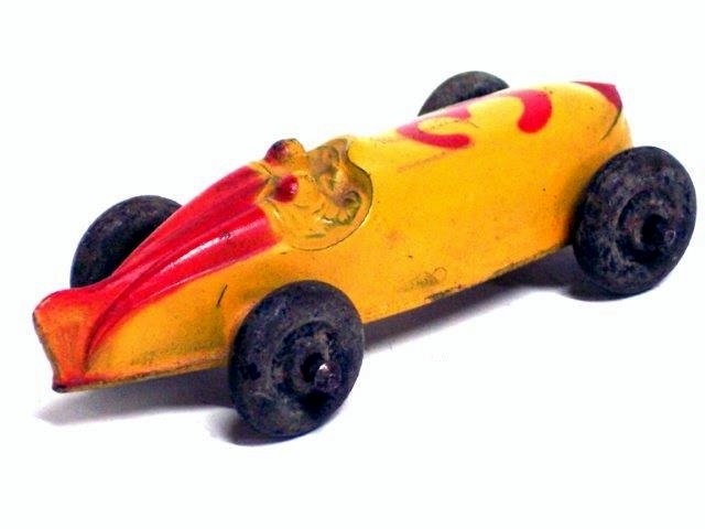 This is a rear quarter view of the yellow race car with red trim and the number 3.