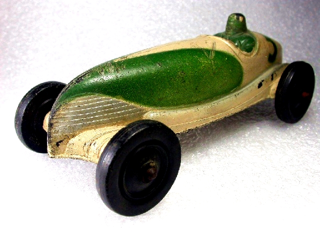 A Sun open racer, six and three quarter inches long, painted green and beige with silver highlights.Some of the tires still have flashing.