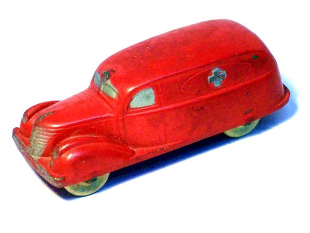 A solid red ambulance with a silver cross in a raised oval on each side, viewed from the front quarter.