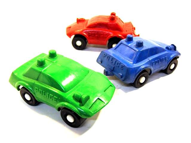 Three police cars, one red, one blue, one green. These look like Firebirds a bit, with retracting headlights, a siren on the hood, a rounded windshield arching up and over the roof (or maybe part of the roof), a kicked up rear end with no apparent trunk below the rear windshield, and on each door the word Police.