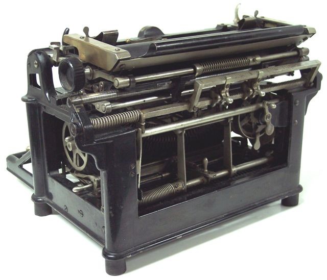 In this photo taken from the left rear corner shows the springs that assist in carriage movement, placement of the two rear margin tabs, and the shift mechanism. The upper frame corners have a lovely support cast in that is a distinctly Victorian touch.