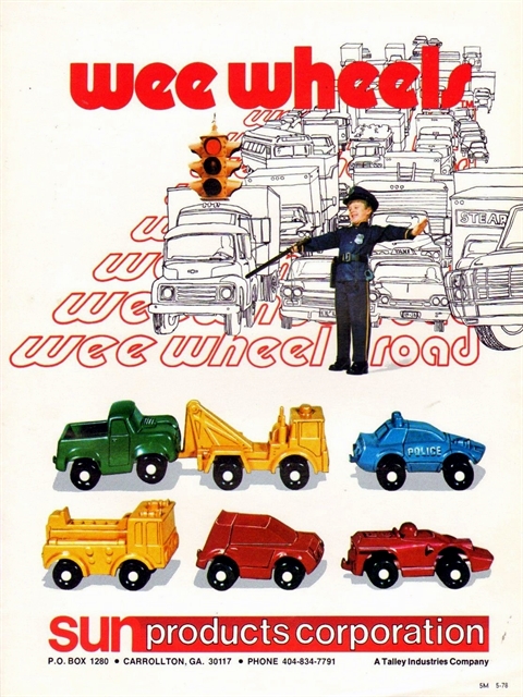 A tall, narrow, full-color poster showing the Wee Wheels line. Wee Wheels is across the top in lower case black-bordered red letters. A traffic signal hangs from the letters, and a black line art drawing of a traffic jam is piled up at the light. A child dressed as a policement is trying to break up the traffic. Below that, photos of six Wee Wheels. Finally, below that is the company name and address.